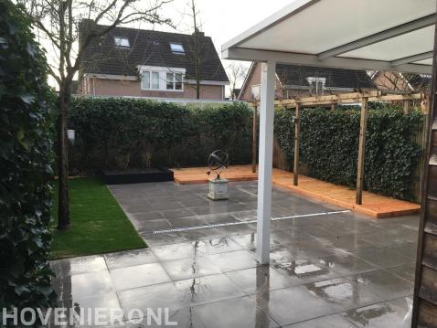 Tuinaanleg met bestrating, kunstgras en houten vlonder en pergola