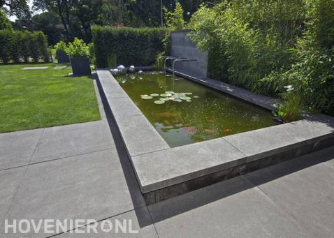 Vijver met waterornament in moderne tuin