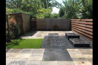 Tuinaanleg met bestrating, split, kunstgras en plantenbakken