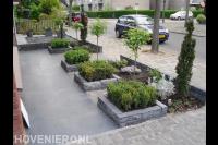 Voortuin met kleine borders van stapelblokken met buxus