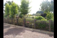 Houten hekwerk langs natuurlijke tuin met veel groen