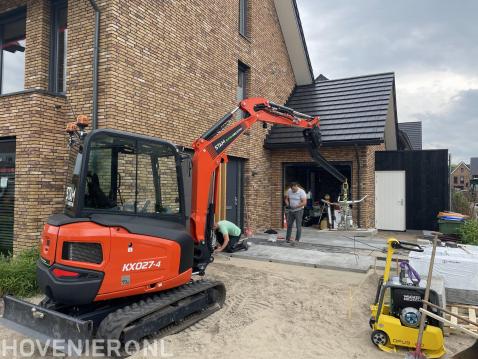 Grond en straatwerk, machinaal tegels leggen.