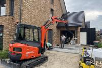 Grond en straatwerk, machinaal tegels leggen.