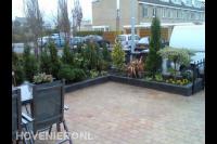 Bestrating met koppelstenen en plantenbakken van stapelblokken