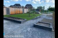 Tuinaanleg met bestrating, gazon, plantenbakken en schutting