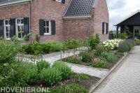 Grindpaden tussen borders met verschillende soorten beplanting