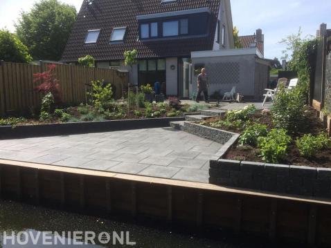 Tuin aan het water met beschoeiing en bestrating