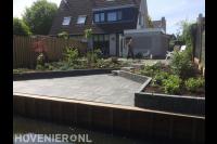 Tuin aan het water met beschoeiing en bestrating