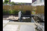 Moderne tuin met vijver, vlonder en grote tuintegels