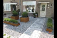 Onderhoudsarme voortuin met grind en houten plantenbakken