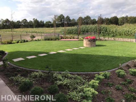 Ruime tuin met groot gazon en nieuwe beplanting