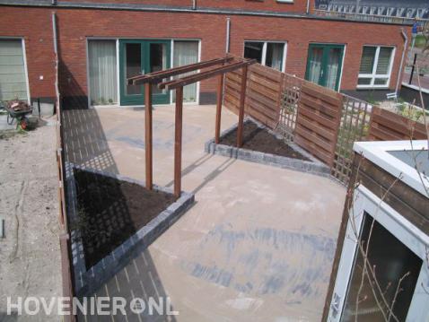 Aanleg achtertuin met bestrating, pergola, schutting en plantenbakken