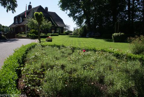 Ruime tuin met veel groen en groot gazon bij villa