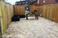 Achtertuin bestraten met natuursteen tegels
