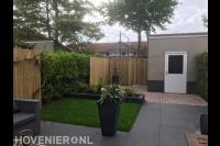 Tuinaanleg met bestrating, gazon, plantenbak en schutting