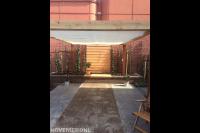 Stadstuin met houten pergola met harmonicadoek