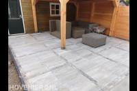 Straatwerk van siertegels en klinkers bij overkapping