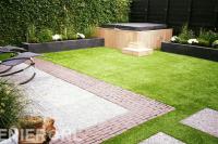 Tuinaanleg met terras, kunstgras, plantenbakken en jacuzzi