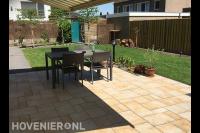 Tuin met terras van siertegels in wildverband en gazon