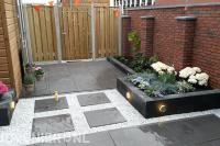 Achtertuin aanleggen met plantenbakken, sierbestrating en grind