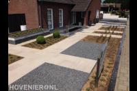 Strakke tuin met siertegels, split, plantenbak en kleine vijver