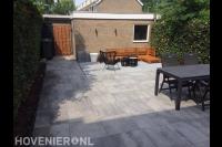Bestrating van natuursteen tegels in achtertuin