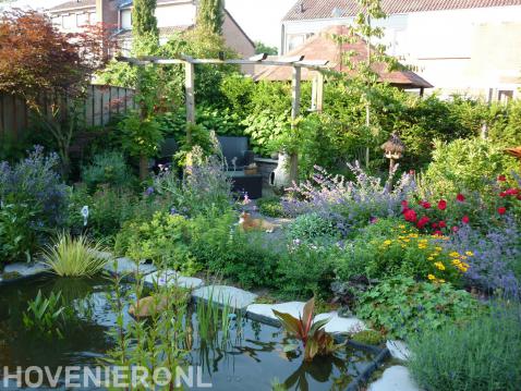 Natuurlijke tuin met vijver, pergola en kleurrijke beplanting