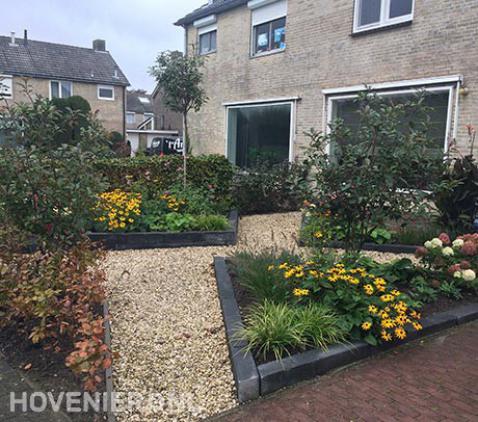 Voortuin met kleurrijke beplanting en looppaden van grind