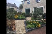 Voortuin met kleurrijke beplanting en looppaden van grind