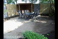 Tuinaanleg met bestrating, houten overkapping en schutting