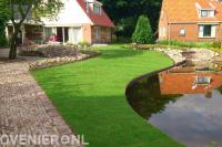 Tuin met vloeiende lijnen en grote vijver met waterval