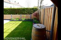 Achtertuin met gazon, waterton en hout beton schutting