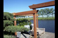 Houten pergola bij vlonder aan het water