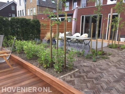 Achtertuin met terras, bestrating van klinkers en houten vlonder