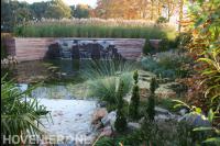 Natuurlijke vijver met grote watermuur