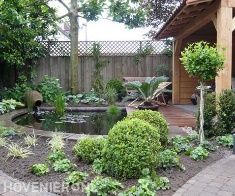 Tuin met houten overkapping, vlonder en vijver 1