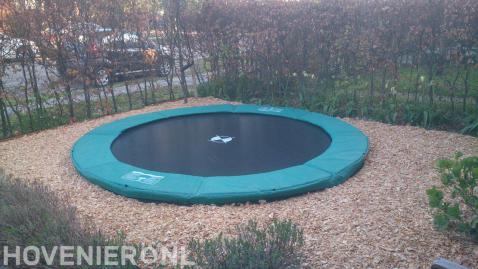 Trampoline omgeven door houtsnippers