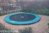 Trampoline omgeven door houtsnippers