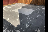 Straatwerk van betontegels met daartussen siertegels