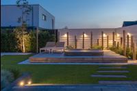 Tuinaanleg met kunstgras, houten vlonder en buitenverlichting