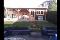 Tuinaanleg met plantenbakken, gazon en schuurtje met overkapping