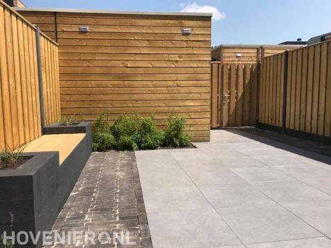 Achtertuin met sierbestrating en hout beton schutting