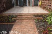 Groene achtertuin met sierbestrating