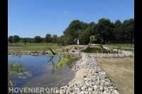 Grote heldere vijver met rotsblokken op oevers