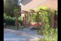 Zithoek met bankje en grote houten pergola