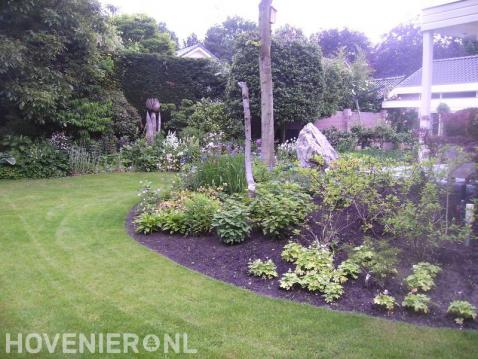 Ruime tuin met gazon en borders