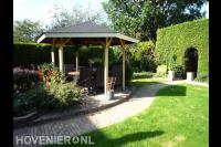 Zithoek met houten overkapping en tuinset bij vijver 2