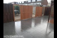 Sierbestrating en houten schutting met panelen van betongaas