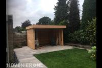 Tuinaanleg met bestrating, kunstgras en houten overkapping