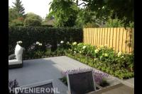 Moderne tuin met grote grijze tuintegels en kleurrijke borders 2